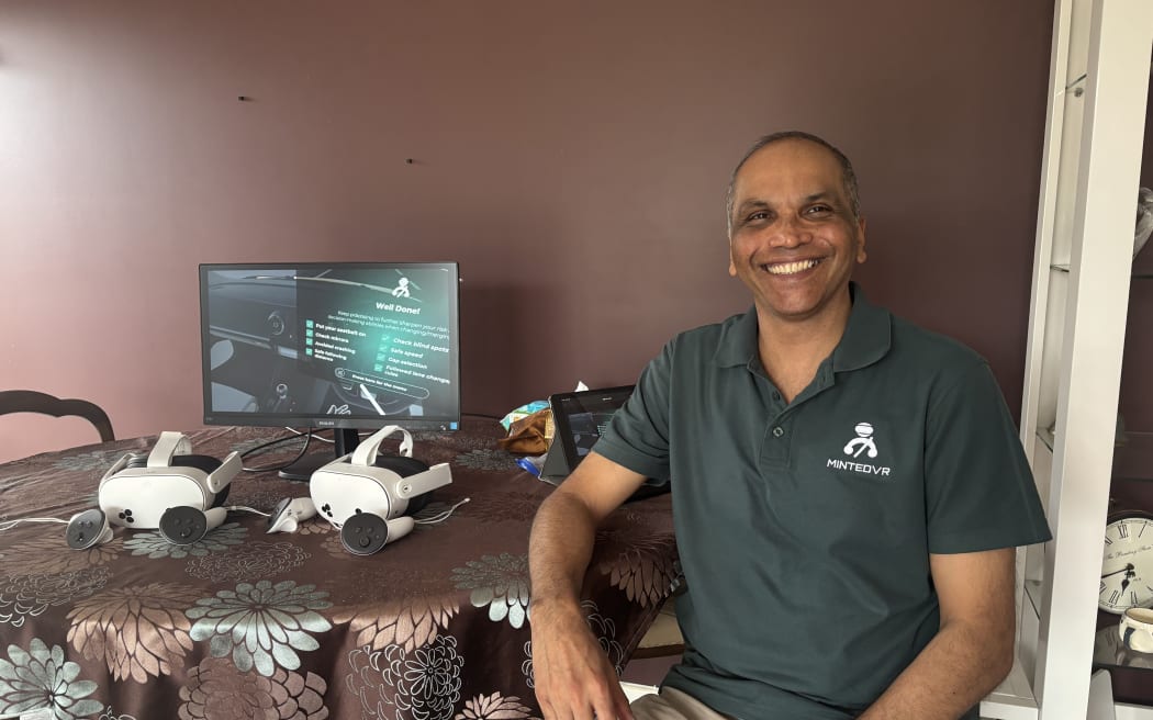 Ashley Gore, creator of MINTEDVR sitting down next to a VR headset