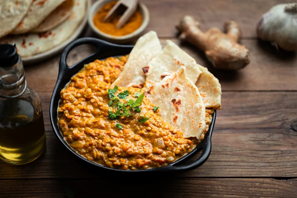 Shot of lentil dahl with rotis