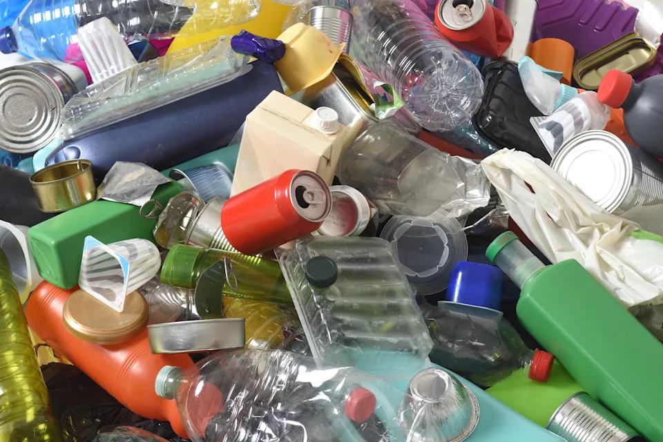 Full frame of trash plastics and cans on white background.