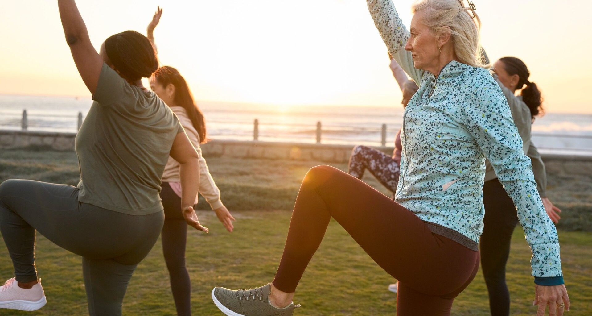 A group of mature exercisers balancing outside during a workout