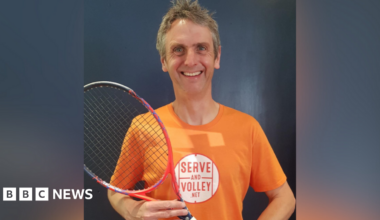 Rob Salmon, wearing an orange t-shirt and holding tennis racket