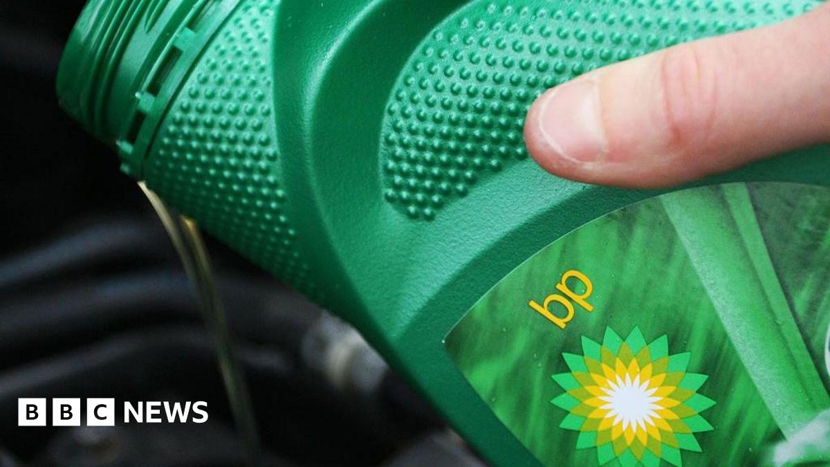 A green BP oil can pouring oil into a car engine