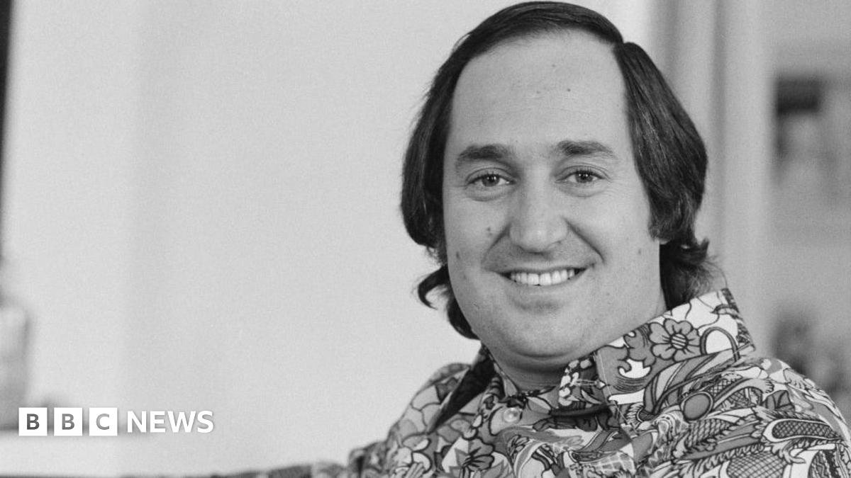 Neil Sedaka in a black and white photo wearing a 1970s style shirt