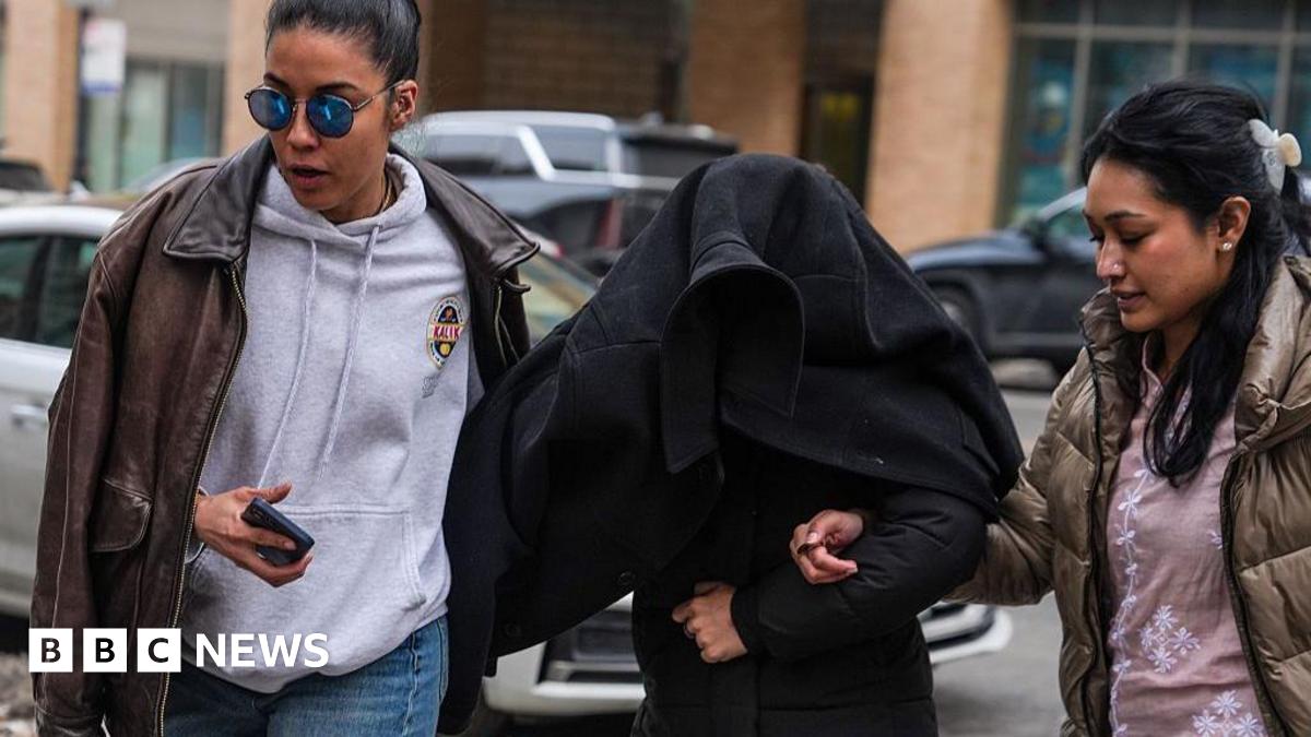 Elmina Aghayeva seen under a jacket being led away by agents