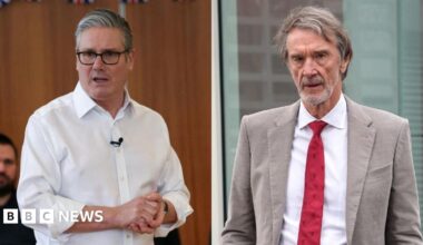 Sir Jim Ratcliffe, who has brown greying hair and a grey stubble beard, wears a beige linen suit jacket with a white shirt and red tie
