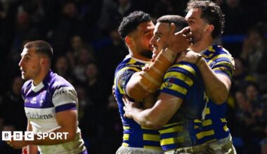 Warrington Wolves player Josh Smith is congratulated by team-mates for scoring a try against Wakefield Trinity