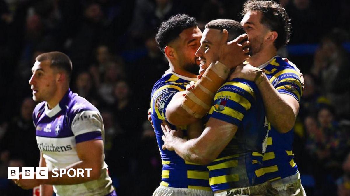 Warrington Wolves player Josh Smith is congratulated by team-mates for scoring a try against Wakefield Trinity