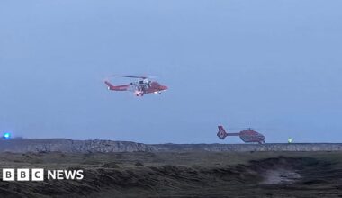Two helicopters around a coastline