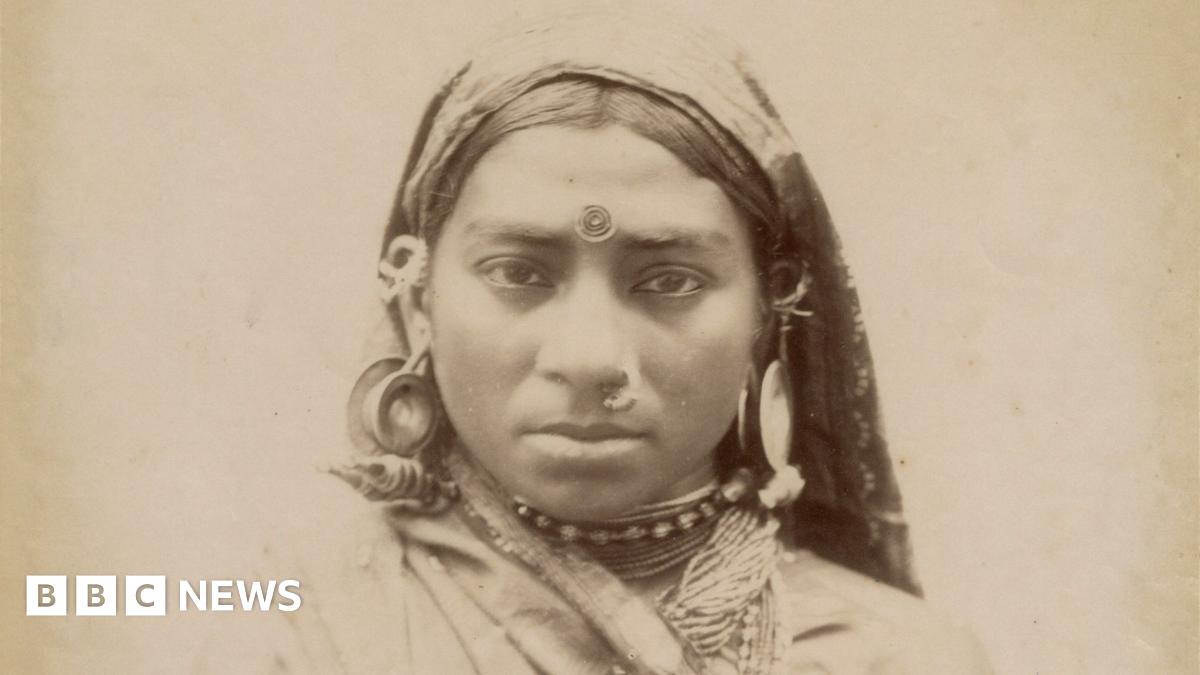A husband, wife and daughter from India pose at an unidentified location in Singapore in the late 19th century, dressed in their traditional attire.