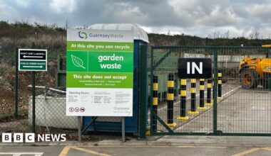 A picture of the entrance to the Mont Cuet site. There is a large green fence with vehicles inside.