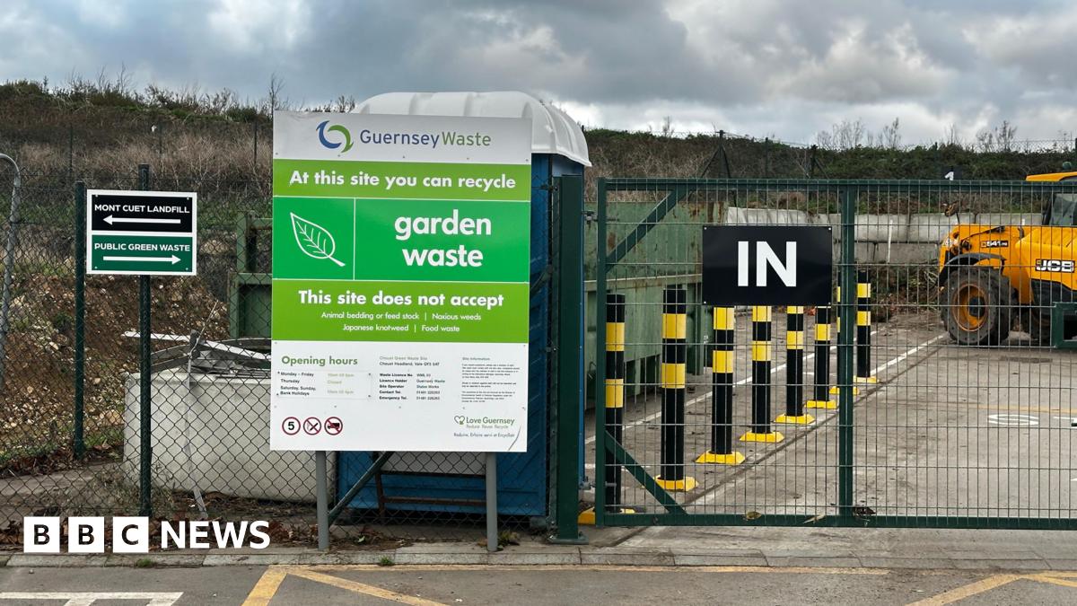 A picture of the entrance to the Mont Cuet site. There is a large green fence with vehicles inside.