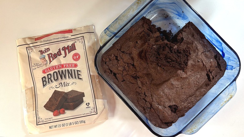 Bag of Bob's Red Mill Gluten Free brownie mix on table next to pan of brownies