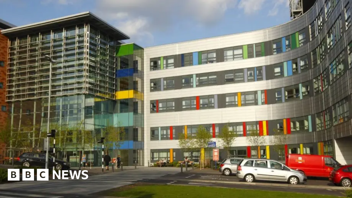 Outside of the Queen Alexandra Hospital building which is made of glass and has colourful tiles at the front.