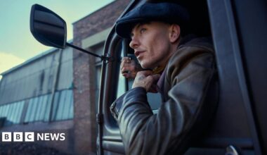 Barry Keoghan and Cillian Murphy facing each other across a table or bar in a scene from the film
