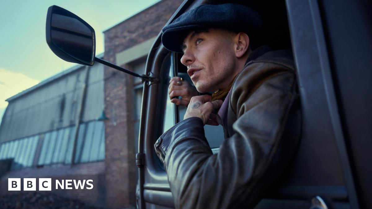 Barry Keoghan and Cillian Murphy facing each other across a table or bar in a scene from the film