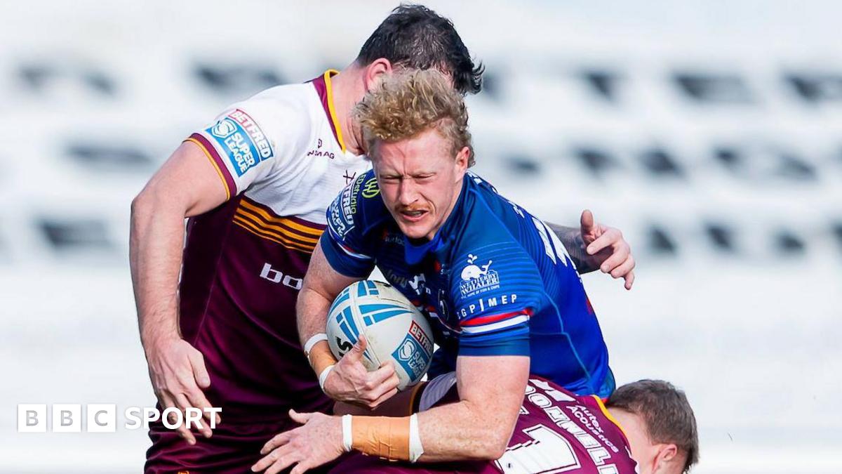 Wakefield Trinity's Lachlan Walmsley drives into the tackle of Huddersfield's Asher O'Donnell