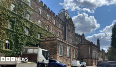 Listed Victorian stone county hall building covered in moss on left side