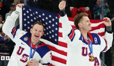 Brady Tkachuk and Matthew Tkachuk hold aloft the United States flag after helping the men's ice hockey team beat Canada to win gold at the 2026 Winter Olympics