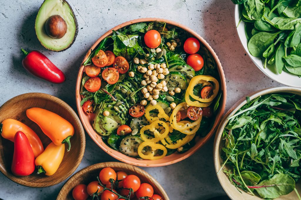 Close up of woman's hand holding a bowl of fresh beef cobb salad, serving on the dining table. Ready to enjoy her healthy and nutritious lunch with coffee. Maintaining a healthy and well-balanced diet. Healthy eating lifestyle