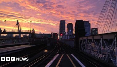 Charing Cross station at sunset. The picture looks out onto the tracks with some of the city scape in the background.