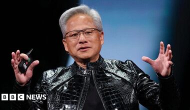 Nvidia's Jensen Huang, in his iconic black leather jacket, speaks on stage, gesturing with his hands up