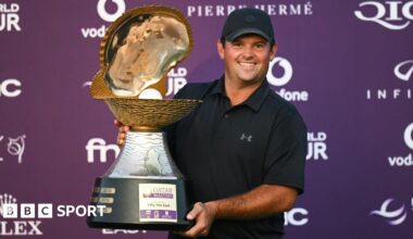 Golfer Patrick Reed smiles as he poses with the Qatar Masters 2026 trophy