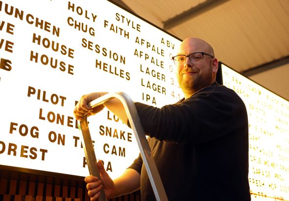 Duncan Dennis in front of a beer menu
