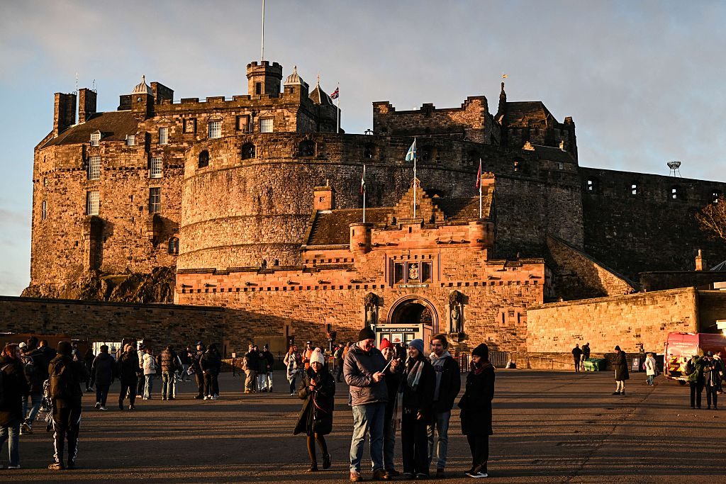 This general view shows tourists outside Edinburgh Castle on December 30, 2025, ahead of the annual Hogmanay street party which culminates in a midnight fireworks display over the castle. An estimated 100,000 people from dozens of countries are expected in Edinburgh for the New Year events, the centrepiece of which is a street party and fireworks display on December 31. (Photo by Andy Buchanan / AFP via Getty Images)