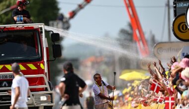 A firefighter atop a fire truck sprays water on spectators to cool them down at the finish line of the 10th stage of the 110th edition of the Tour de France cycling race, 167,5 km between Vulcania and Issoire, in the Massif Central highlands in central France, on July 11, 2023. (Photo by Anne-Christine POUJOULAT / AFP)