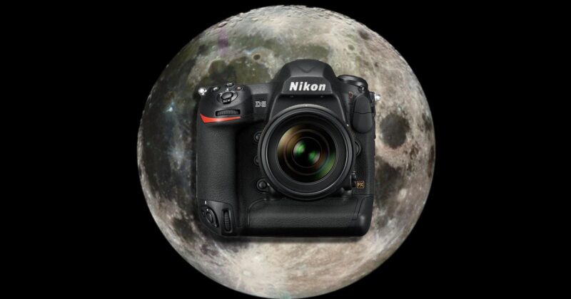 A Nikon DSLR camera is centered in front of a large, detailed image of the full moon, both set against a black background.