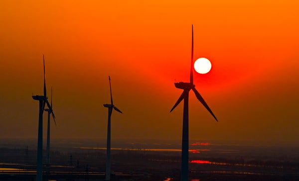 Wind turbines rotates against the wind in a vast coastal mudflat in China