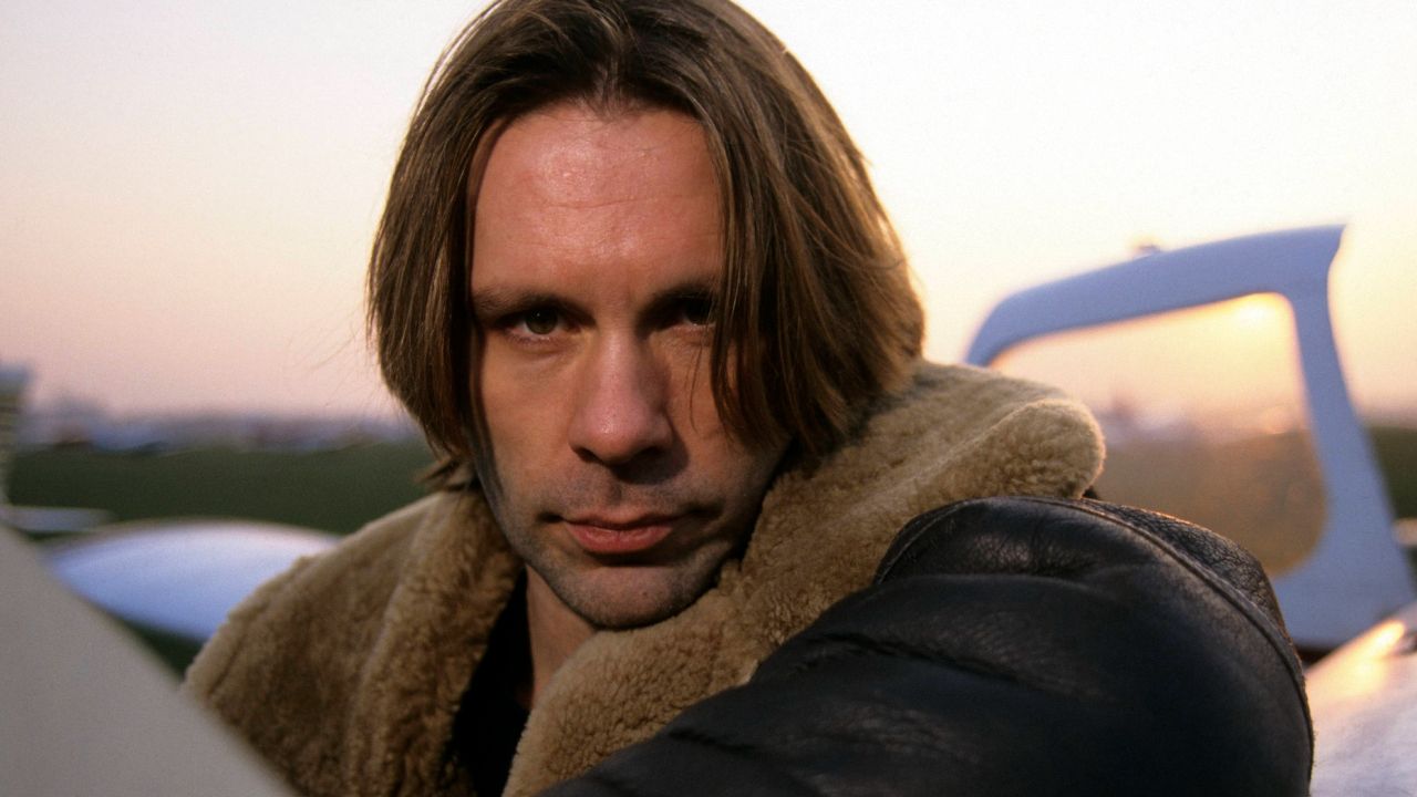 Bruce Dickinson leaning against an aircraft in 1996