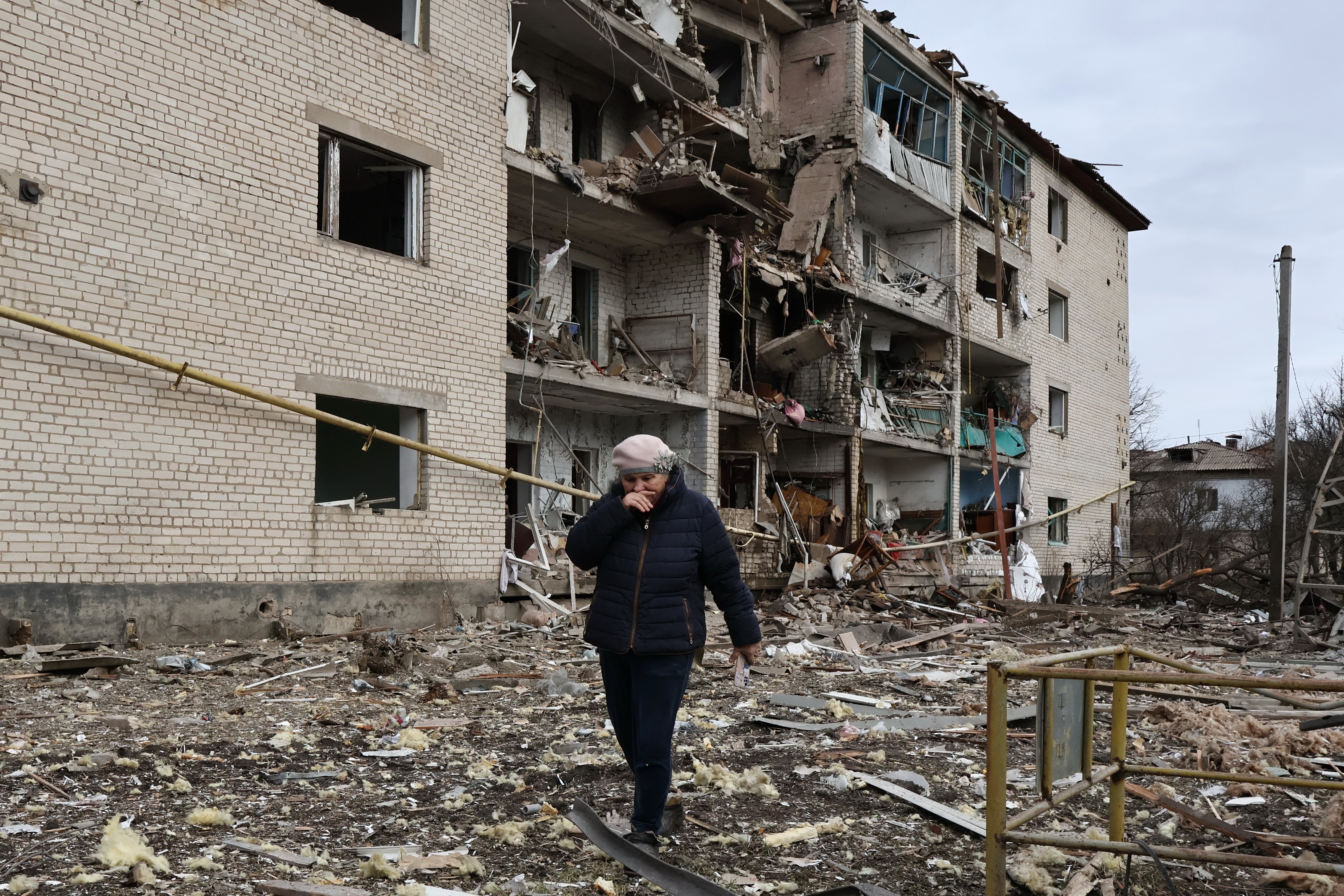 In this photo provided by Ukraine's 65th Mechanized Brigade press service, a local passes by a destroyed apartment building following an Russian air strike in the town of Komyshuvakha in the Zaporizhzhia region of Ukraine on 20 February.