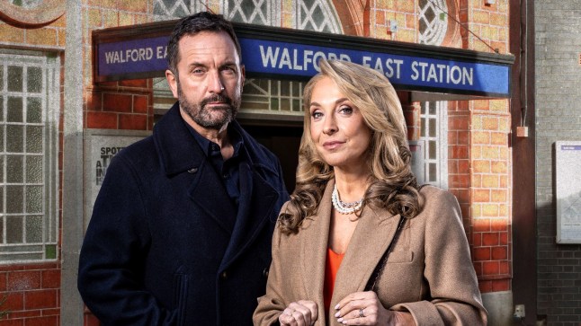 Jake Moon and Chrissie Watts pose in front of Walford East Station in EastEnders