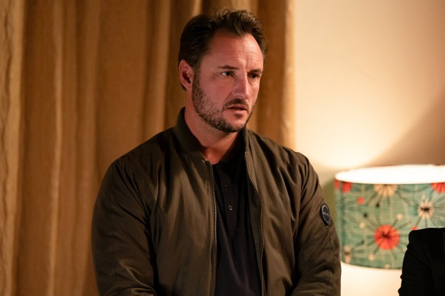 Martin Fowler standing in the Slater household in EastEnders, looking concerned.