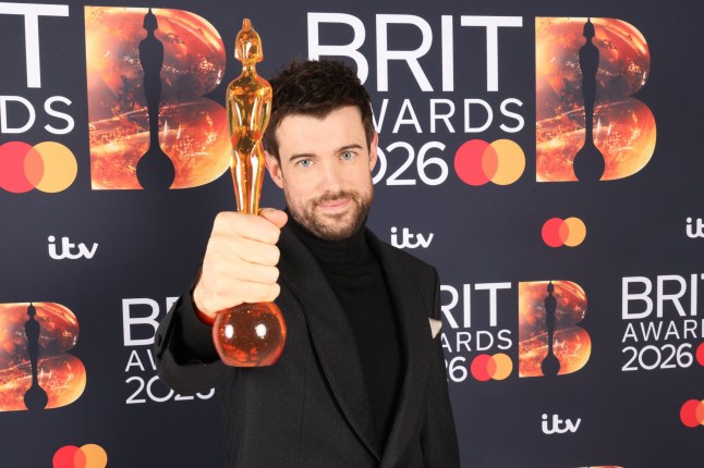 Host Jack Whitehall holding a Brit award