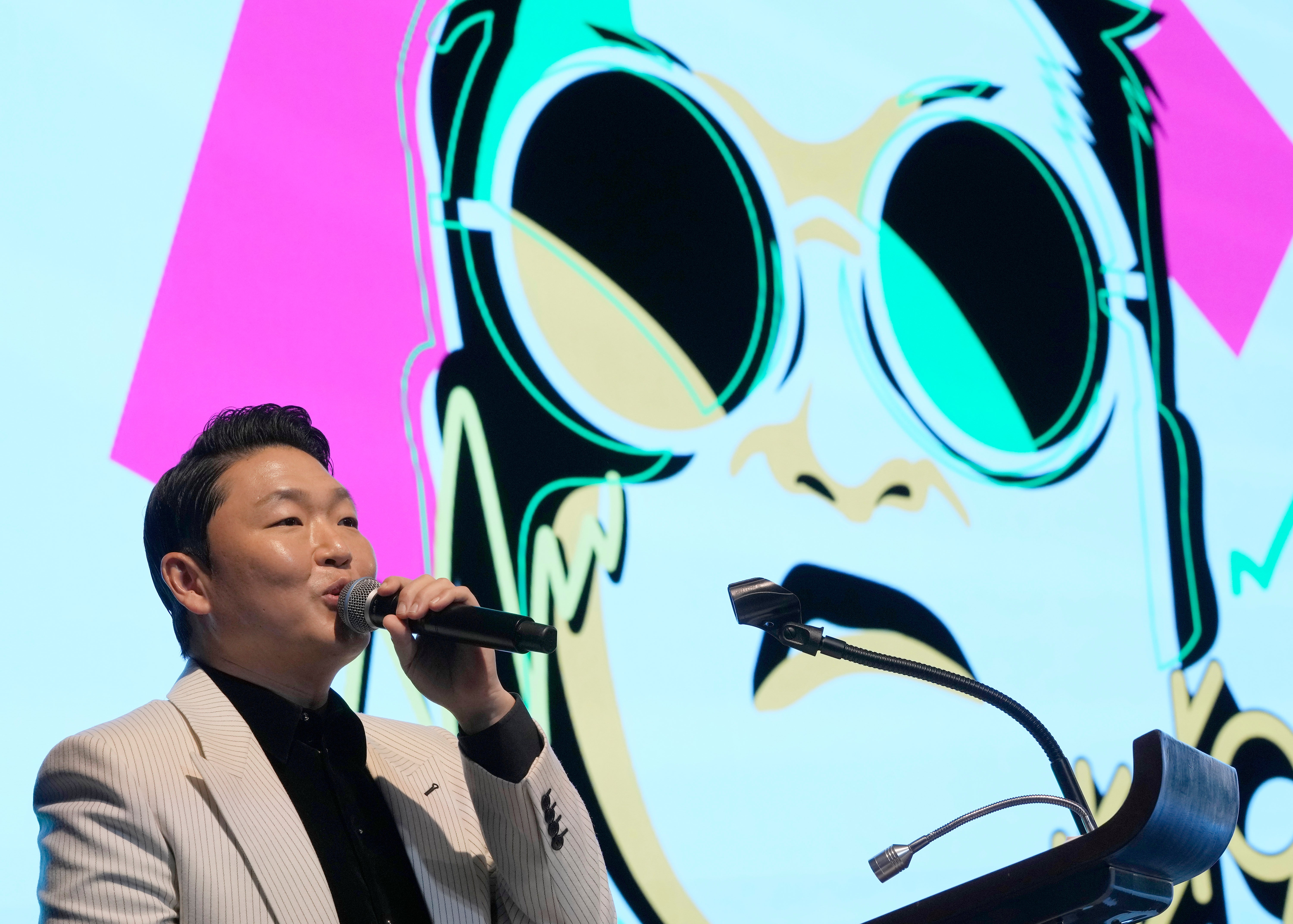 South Korea’s PSY in front of a caricature of himself in 2022