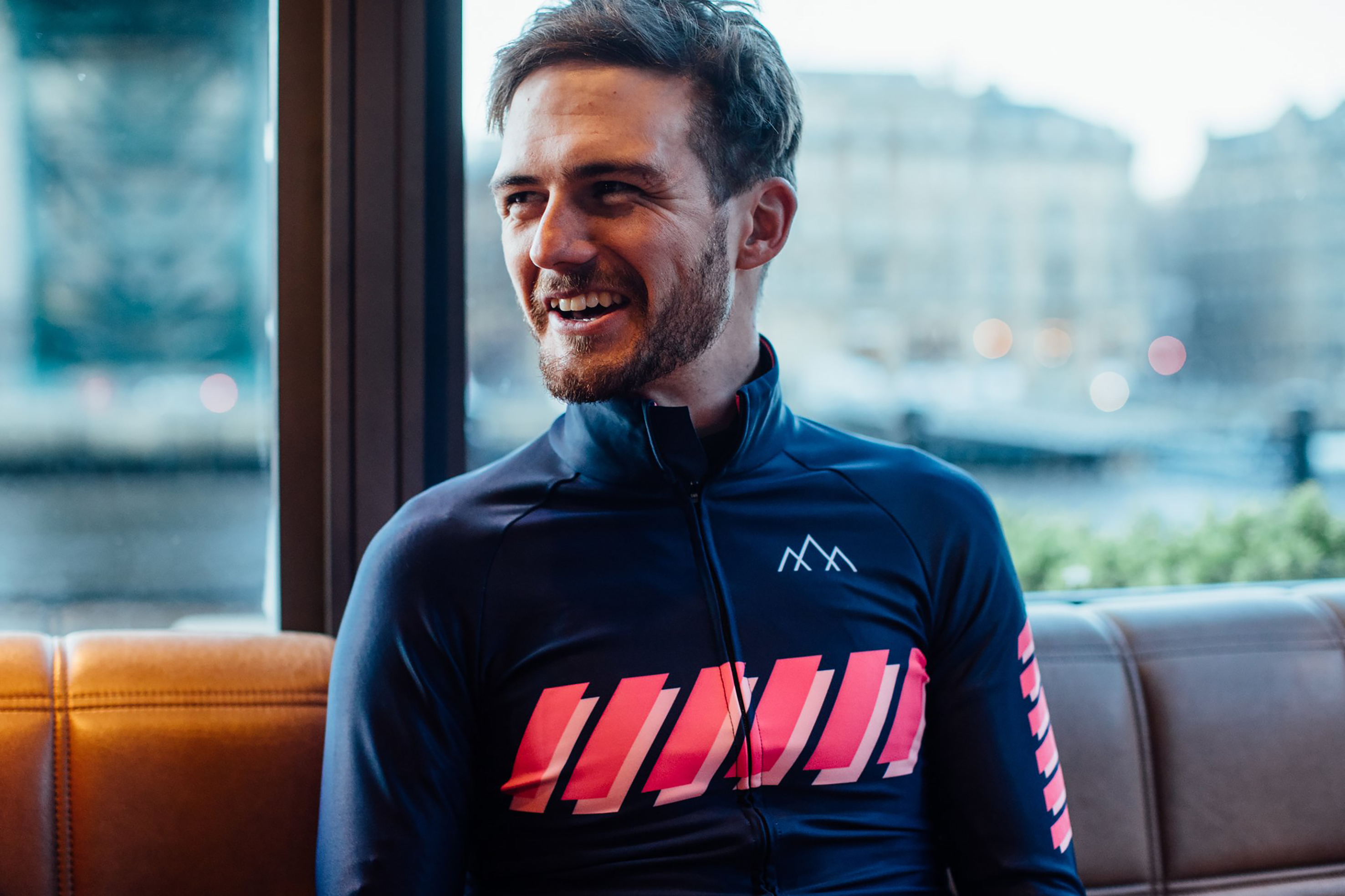 Man laughs wearing cycling jersey with pink stripes