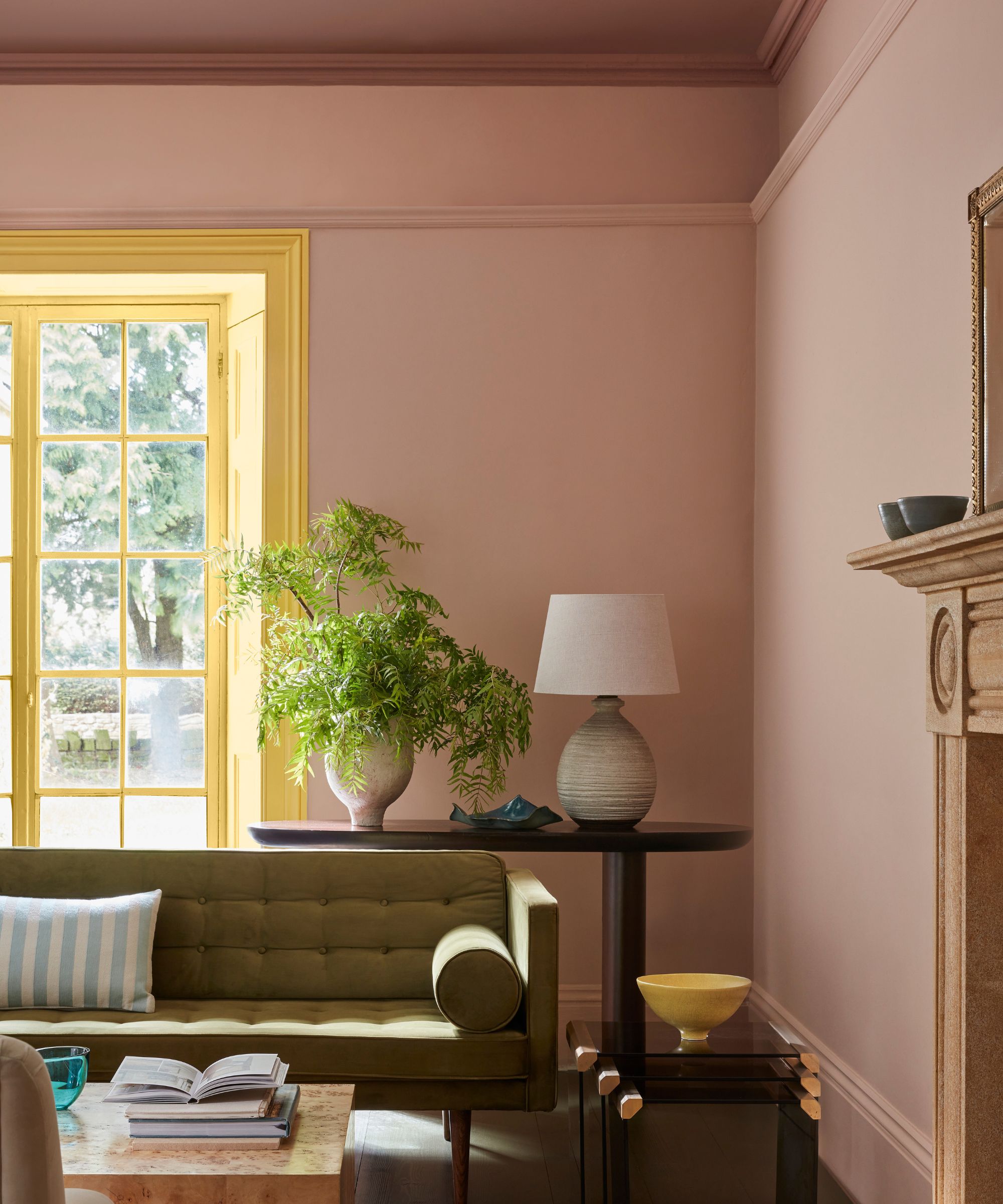 soft pink living room with a large window painted yellow and a darker pink accent ceiling