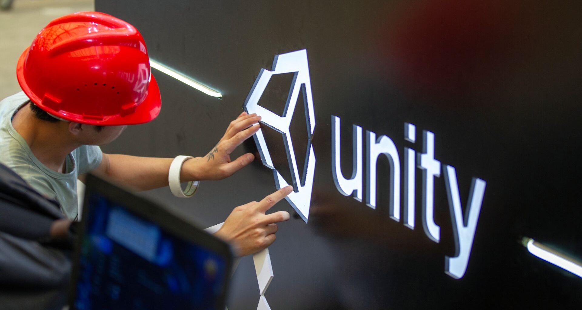 A worker installs Unity logo at Unity Technologies booth one day before the China Digital Entertainment Expo &amp; Conference (ChinaJoy) at Shanghai New International Expo Center on August 1, 2019 in Shanghai, China.