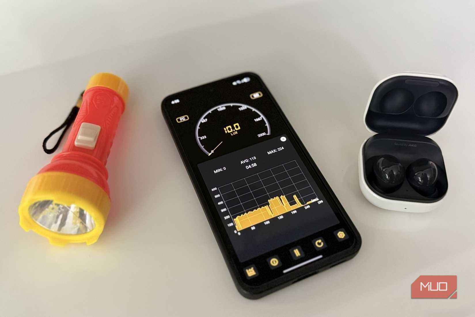 Android phone with a flashlight and earbuds next to it