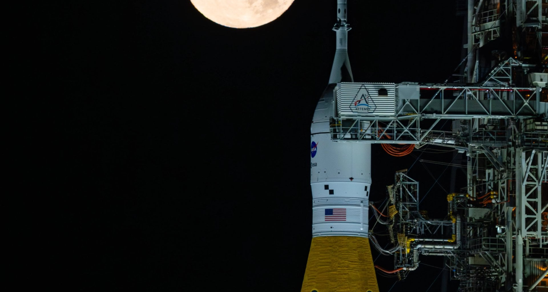 A full Moon is seen shining over NASA’s SLS (Space Launch System) and Orion spacecraft, atop the mobile launcher at the agency’s Kennedy Space Center in Florida on Feb. 1st, 2026. Credit: NASA/Sam Lott