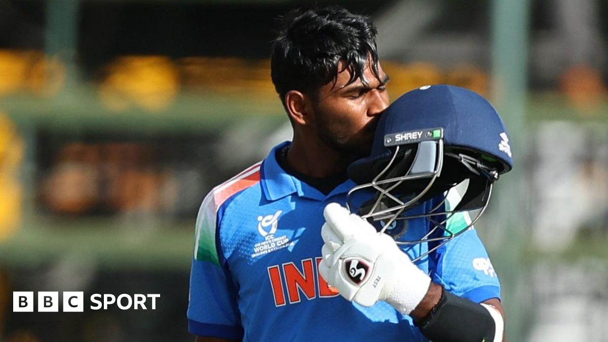 Aaron George celebrates his century by kissing his helmet