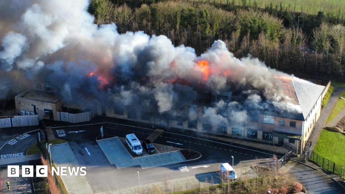 Plumes of smoke and flames pour into the sky at a school site in Devon.
