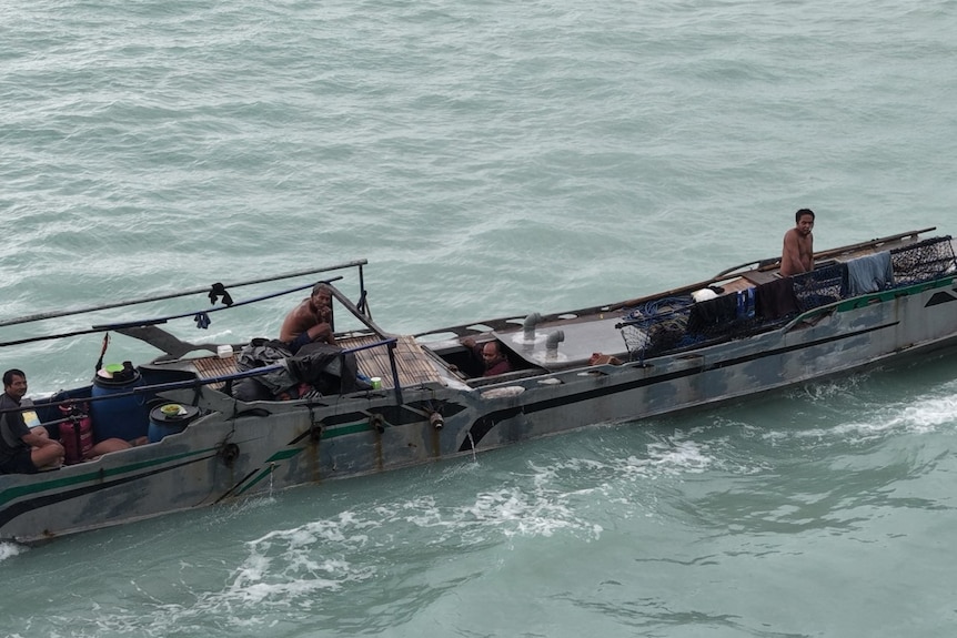 A long, very narrow boat with several people sitting on top.