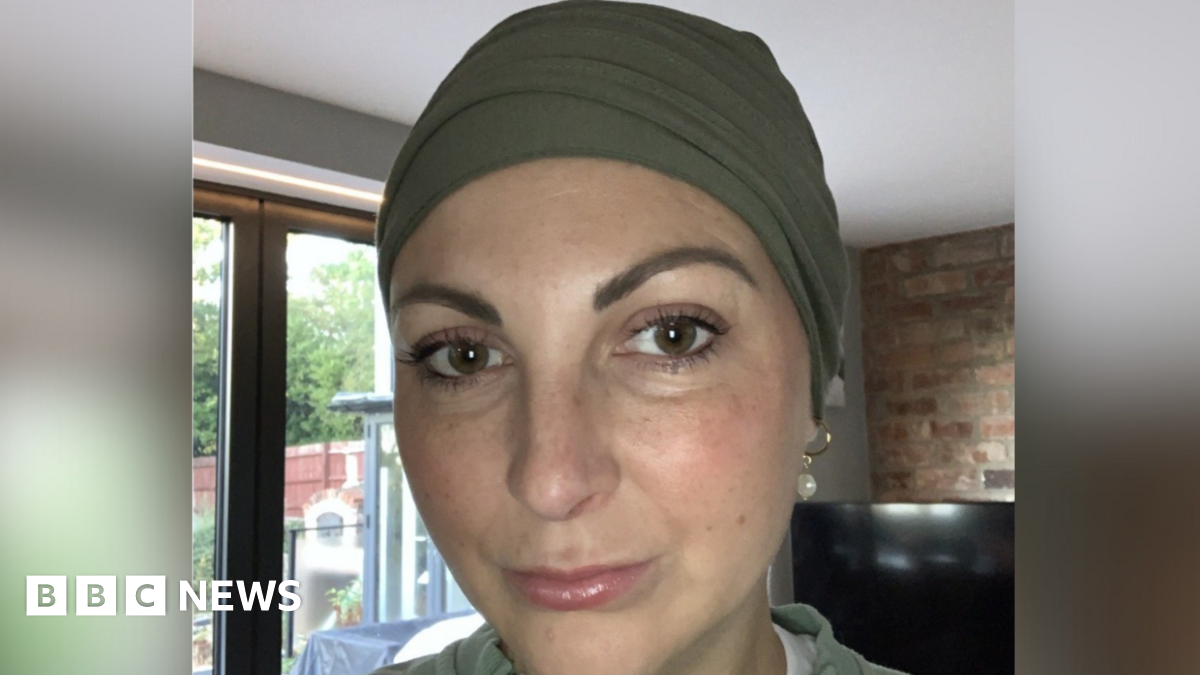 A woman looking down the lens of the camera. She is expressionless.