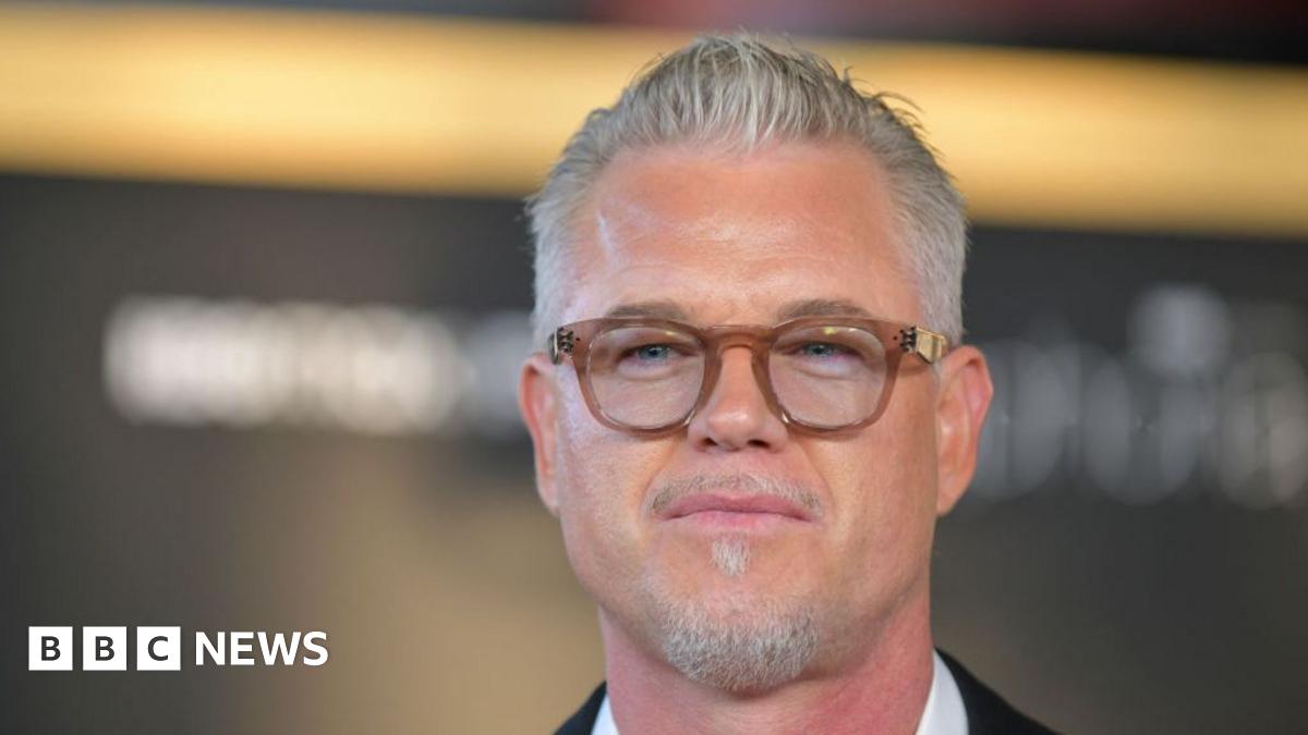 Eric Dane wears glasses and looks at the camera