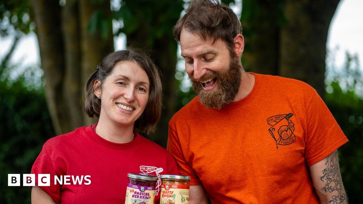 John McAllister in a stadium at the Winter Olympics. Behind him is an ice hockey rink
