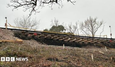 A picture from beneath the landslip, which shows train tracks dangling in the air.