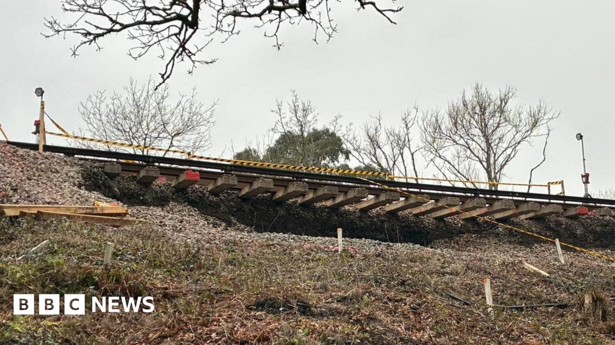 A picture from beneath the landslip, which shows train tracks dangling in the air.